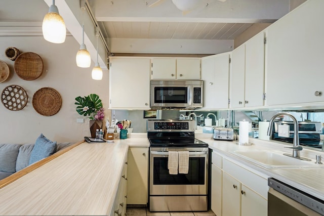 kitchen with sink, stainless steel appliances, hanging light fixtures, beamed ceiling, and white cabinets