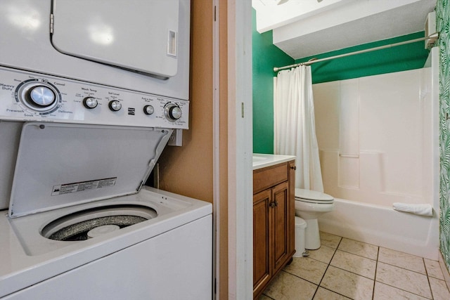 washroom featuring stacked washer / dryer and light tile patterned floors