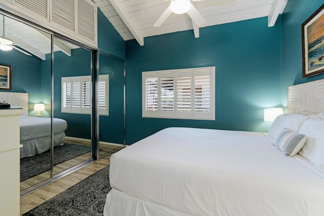 bedroom featuring ceiling fan, wooden ceiling, lofted ceiling with beams, a closet, and hardwood / wood-style flooring