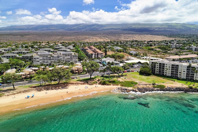 drone / aerial view with a beach view and a water and mountain view