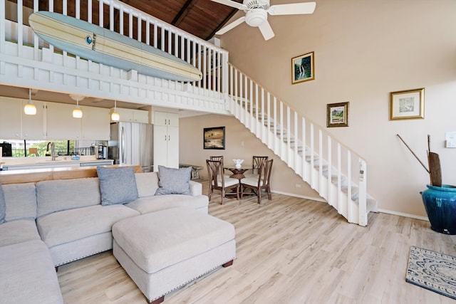 living room featuring high vaulted ceiling, ceiling fan, beamed ceiling, light hardwood / wood-style floors, and wood ceiling