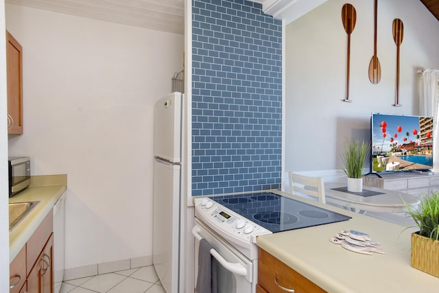 kitchen featuring light tile patterned floors and white appliances