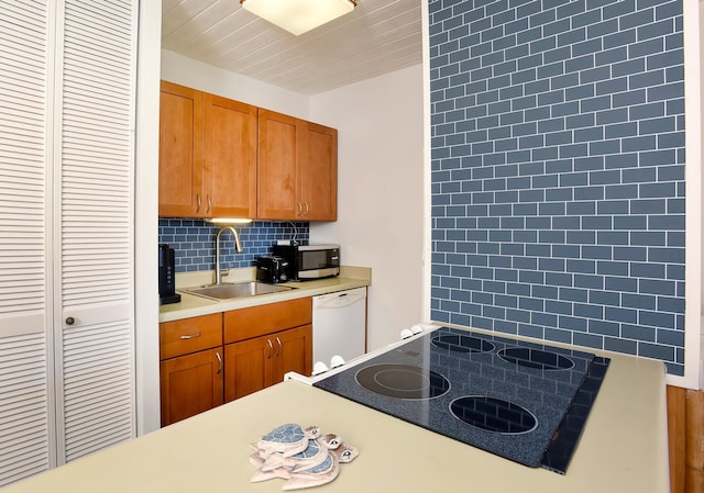 kitchen featuring white dishwasher, tasteful backsplash, and sink