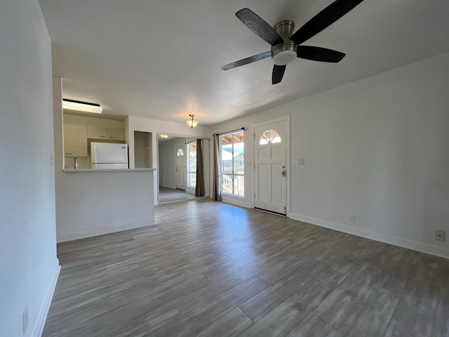 unfurnished living room with hardwood / wood-style floors and ceiling fan