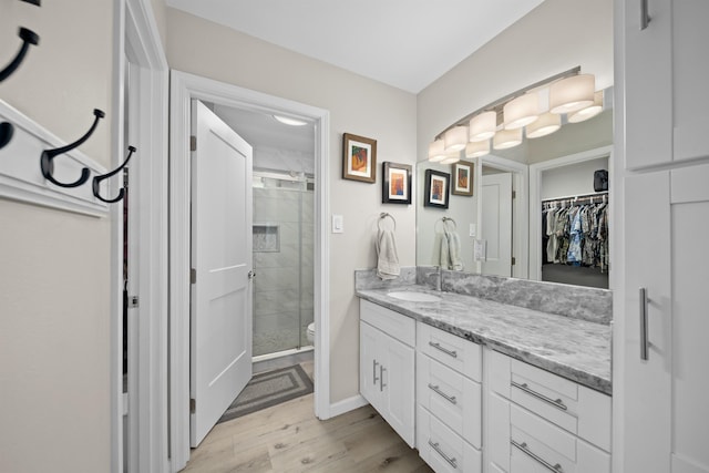 155 Aliilani Pl, Kihei, HI 96753 - bathroom featuring a shower stall, wood finished floors, vanity, toilet, and a spacious closet