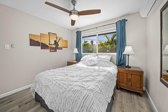 155 Aliilani Pl, Kihei, HI 96753 - bedroom featuring a wall mounted air conditioner, light wood-style flooring, baseboards, and a ceiling fan