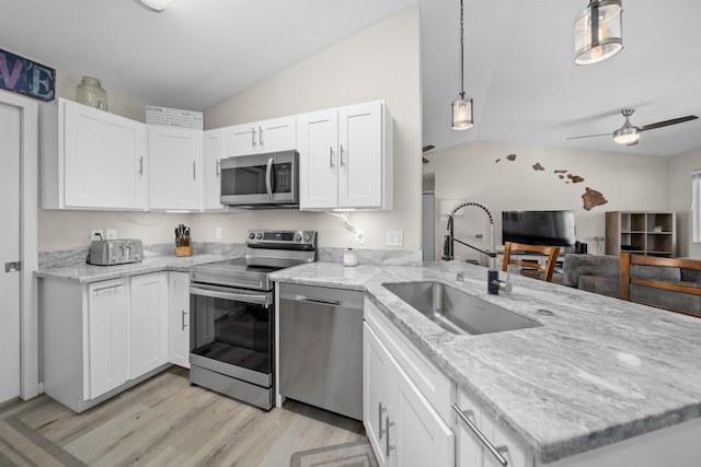 155 Aliilani Pl, Kihei, HI 96753 - kitchen with appliances with stainless steel finishes, vaulted ceiling, a sink, open floor plan, and light wood-style floors