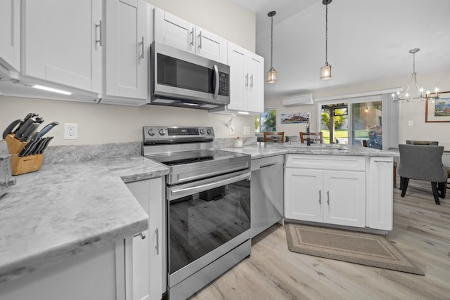 155 Aliilani Pl, Kihei, HI 96753 - kitchen featuring stainless steel appliances, a sink, a wall mounted air conditioner, a peninsula, and light wood-type flooring