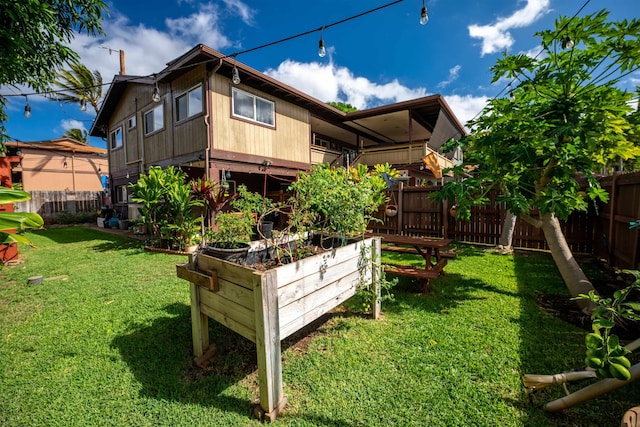 rear view of house with a balcony and a lawn