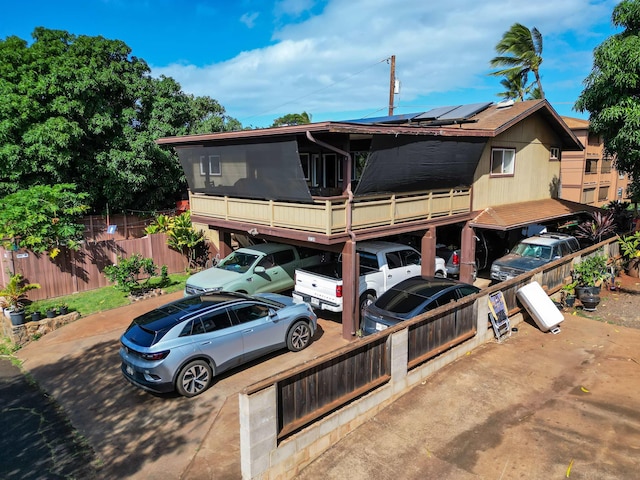 rear view of property featuring solar panels