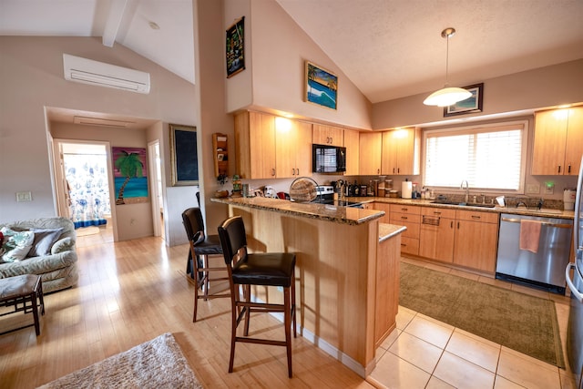 kitchen with sink, a breakfast bar area, a wall mounted air conditioner, stone counters, and stainless steel appliances