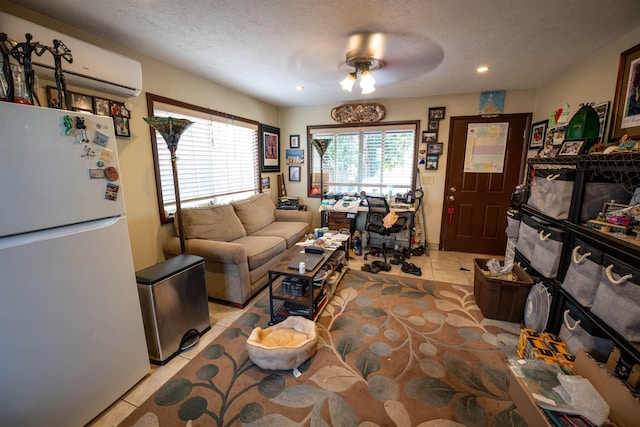 living room with light tile patterned flooring, ceiling fan, a textured ceiling, and an AC wall unit