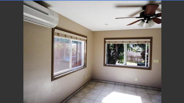 tiled spare room featuring a wall mounted air conditioner and ceiling fan