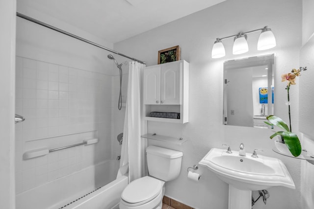 bathroom with toilet, shower / tub combo with curtain, and a sink