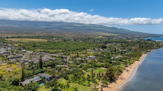 drone / aerial view featuring a water and mountain view, a view of the beach, and a residential view
