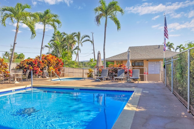 pool with a patio, fence, and a community hot tub
