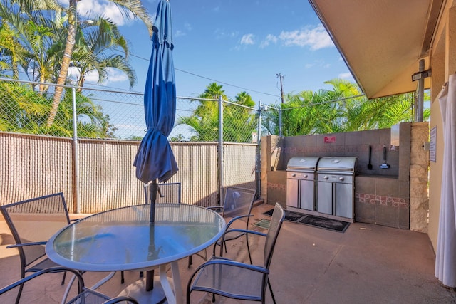 view of patio featuring fence, area for grilling, and outdoor dining area