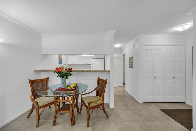 dining area with crown molding, baseboards, and light tile patterned floors