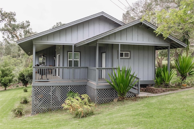 view of front of property with a porch, a front lawn, and board and batten siding