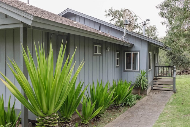 view of side of home with board and batten siding and roof with shingles