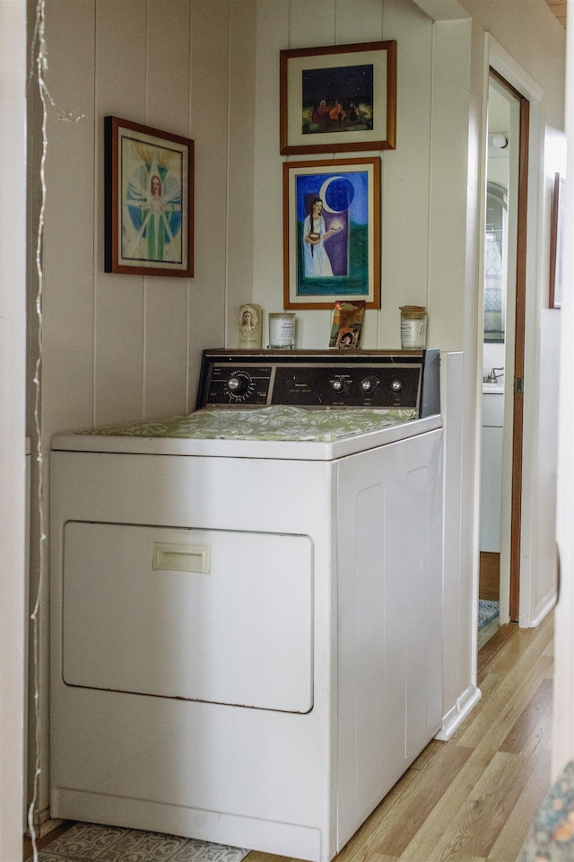 clothes washing area featuring washer / dryer, light wood-style flooring, and laundry area