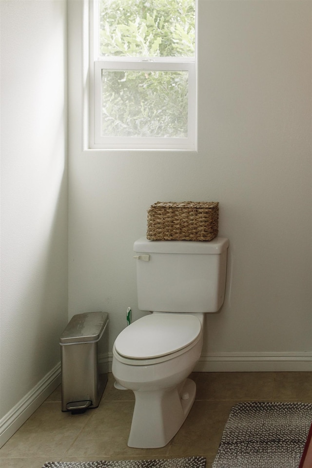 bathroom with baseboards, tile patterned flooring, and toilet