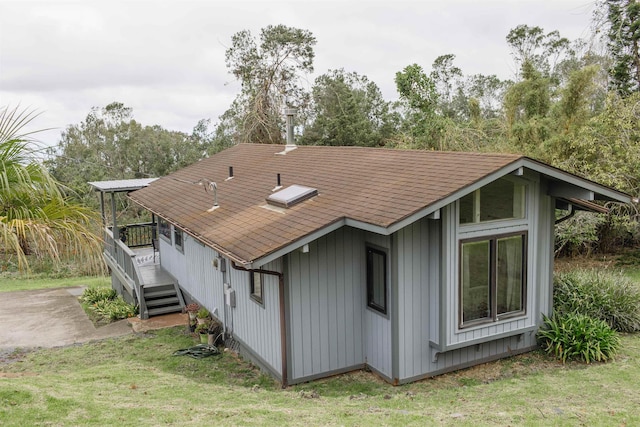 view of property exterior featuring a lawn and a wooden deck