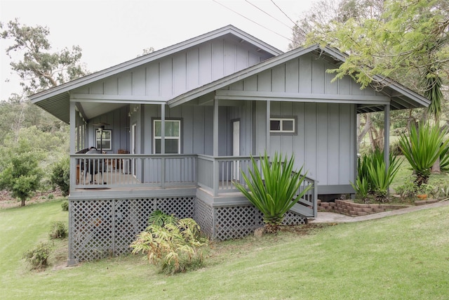 rear view of property featuring a lawn and a porch