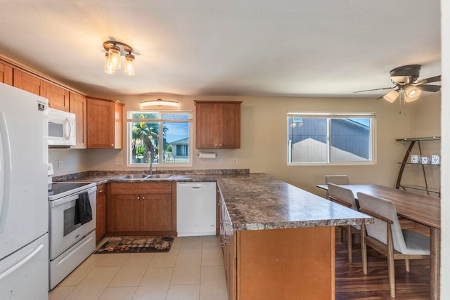 885 Haunani Pl, Wailuku, HI 96793 - kitchen featuring white appliances, a peninsula, dark countertops, brown cabinets, and a sink
