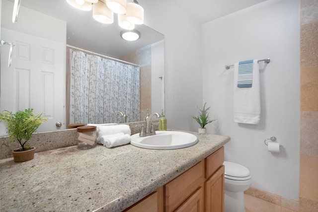 bathroom with tile patterned floors, vanity, toilet, and an inviting chandelier