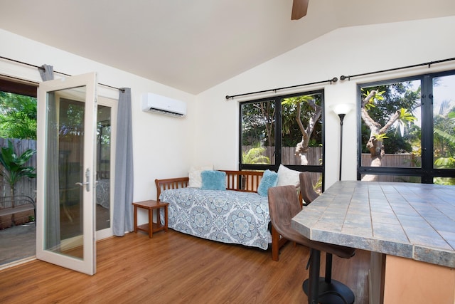 bedroom with hardwood / wood-style floors, ceiling fan, a wall unit AC, and multiple windows