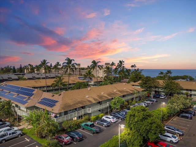 aerial view at dusk featuring a water view