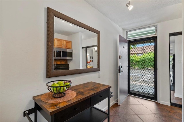 entryway with tile flooring and a textured ceiling