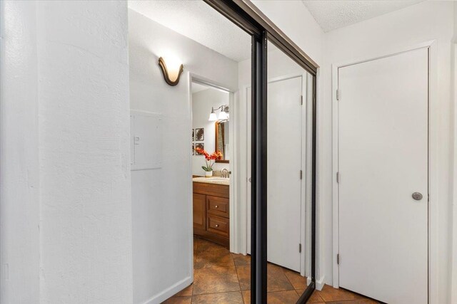 hall featuring tile flooring and a textured ceiling