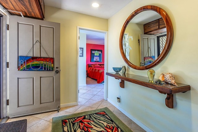 hall featuring baseboards and light tile patterned flooring