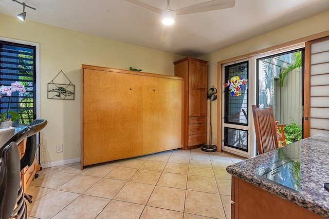 interior space with light tile patterned floors, track lighting, and baseboards