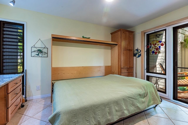 bedroom featuring light tile patterned floors, access to outside, and baseboards