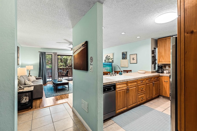 kitchen with dishwasher, sink, and light tile patterned floors