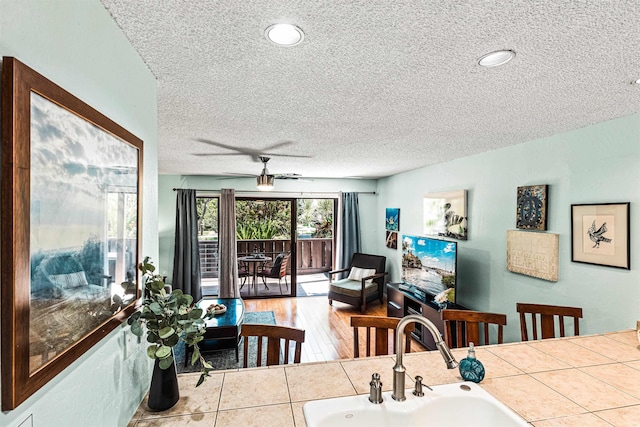 dining space featuring a textured ceiling, ceiling fan, and sink