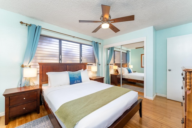 bedroom featuring ceiling fan, a closet, hardwood / wood-style floors, and a textured ceiling