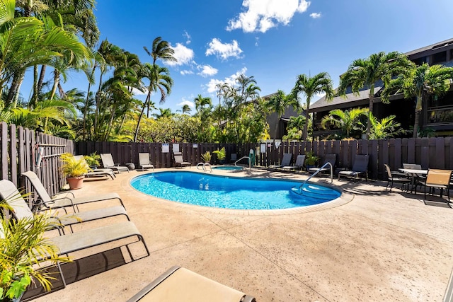 view of pool with a patio area and an in ground hot tub