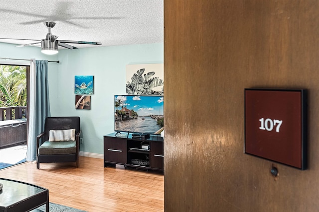 interior space featuring ceiling fan, hardwood / wood-style floors, and a textured ceiling