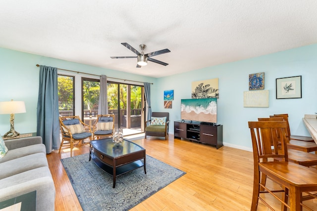 living room with ceiling fan, hardwood / wood-style floors, and a textured ceiling