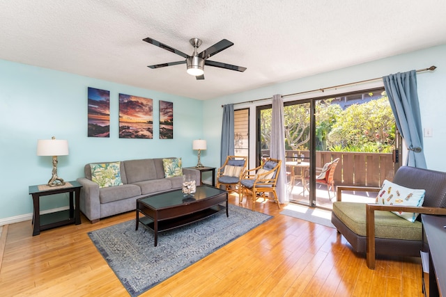 living room featuring hardwood / wood-style floors, ceiling fan, and a textured ceiling