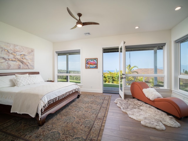 bedroom featuring dark hardwood / wood-style floors, access to outside, and ceiling fan