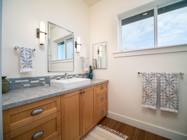 bathroom with vanity, wood-type flooring, and decorative backsplash