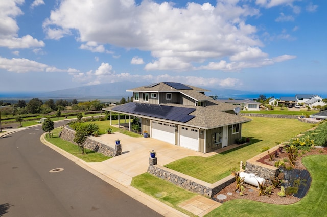 view of front of house featuring a garage, a front lawn, and solar panels