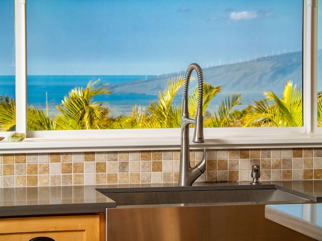 details featuring a water view, sink, and light brown cabinets