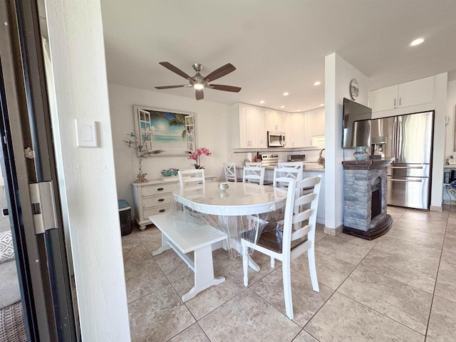 dining room featuring recessed lighting, ceiling fan, light tile patterned floors, and a fireplace