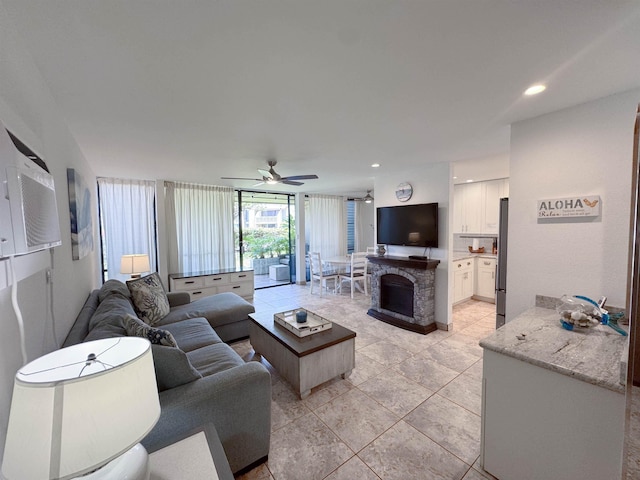 living room featuring a ceiling fan, recessed lighting, light tile patterned floors, and a fireplace